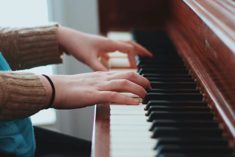 woman's hand playing on piano close up