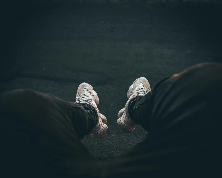 two feet wearing sneakers, while sitting down