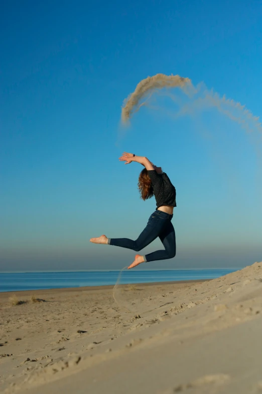 a woman in jeans is doing a trick