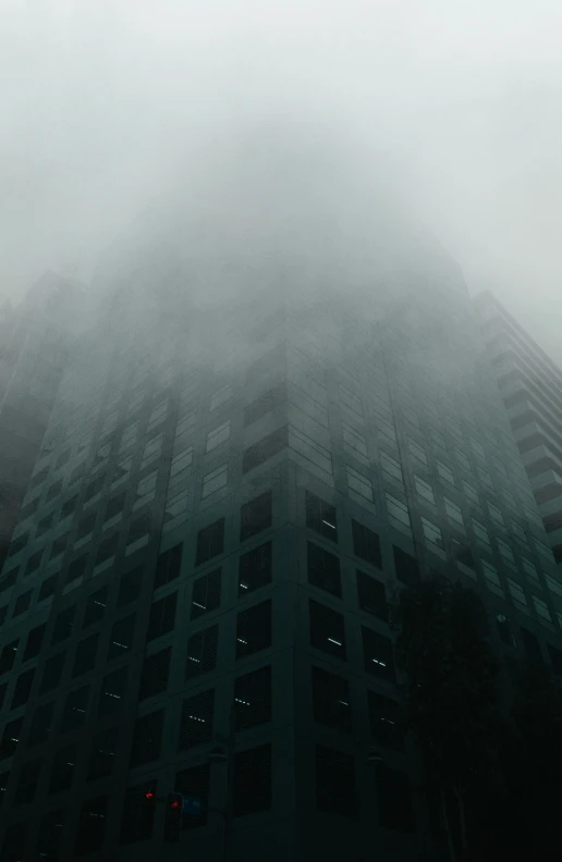 building in fog with large windows and the top of it covered with lights