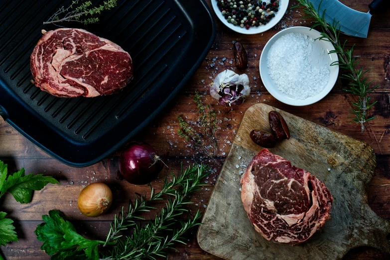 fresh raw meats sitting on top of a  board