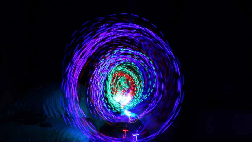 a purple spinning object is lit up with red and blue light