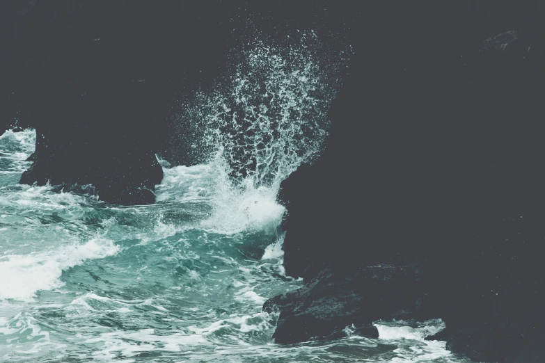 large water splashing from ocean near rocky shoreline