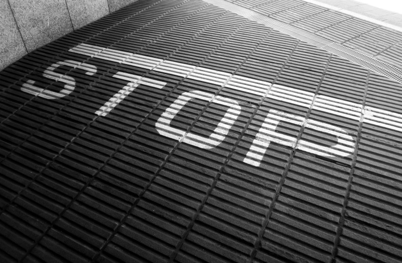 an arrow made out of white lettering sitting on top of a tiled floor