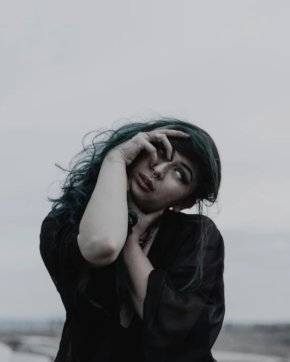 a woman with a long hair and a black shirt is staring in the sky