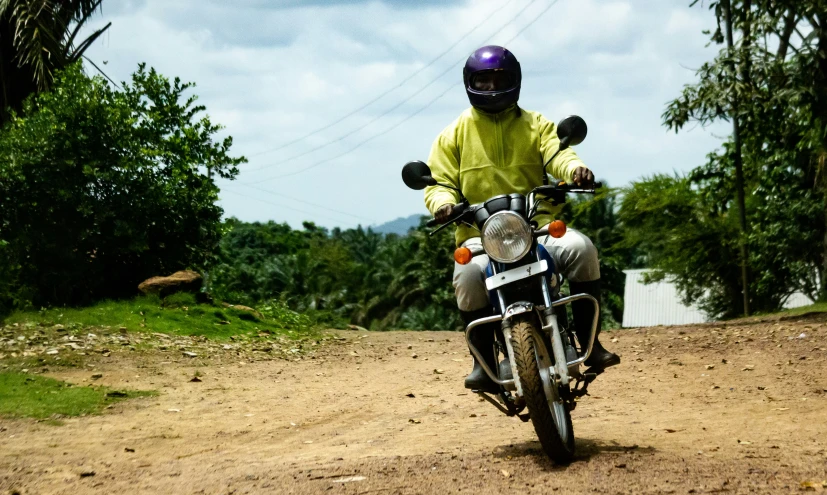 a man in yellow jacket and helmet riding a motorcycle