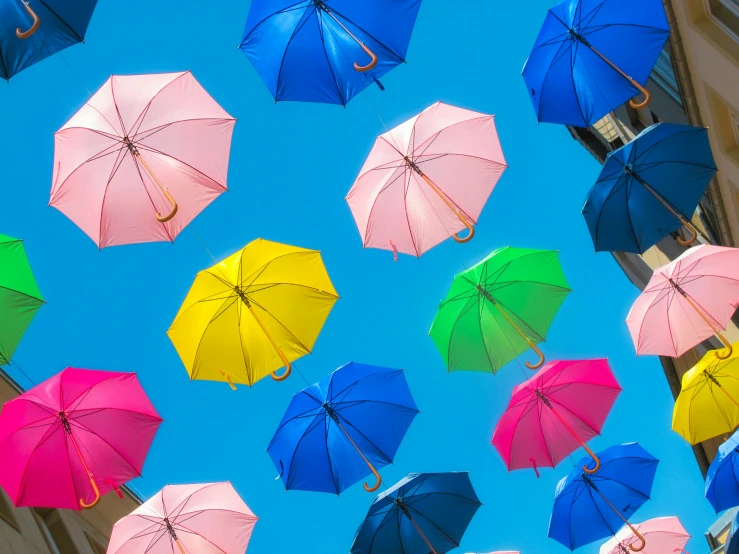 colorful open umbrellas floating in the air above them