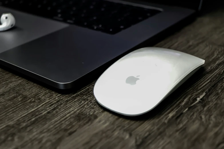 an apple mouse sits on a wood table