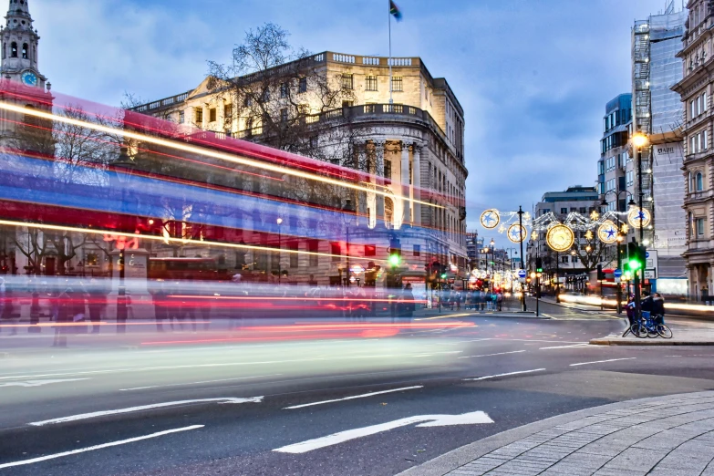 a double - decker bus is traveling through the city