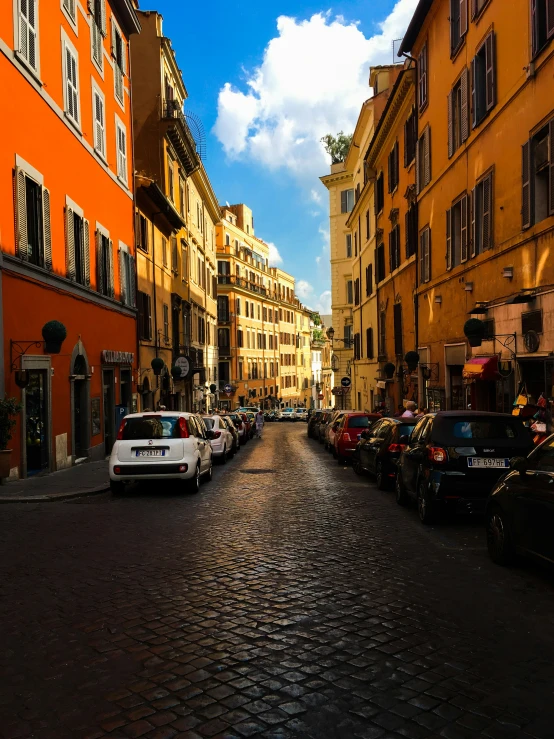 cars parked along a brick street in a city