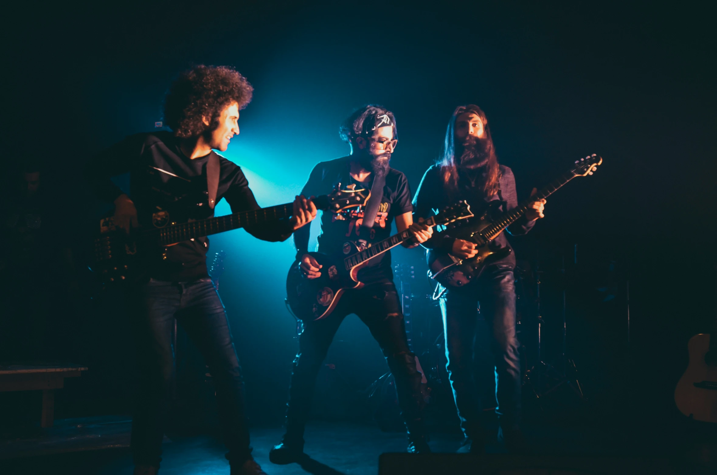 three young people are playing a musical band in the dark