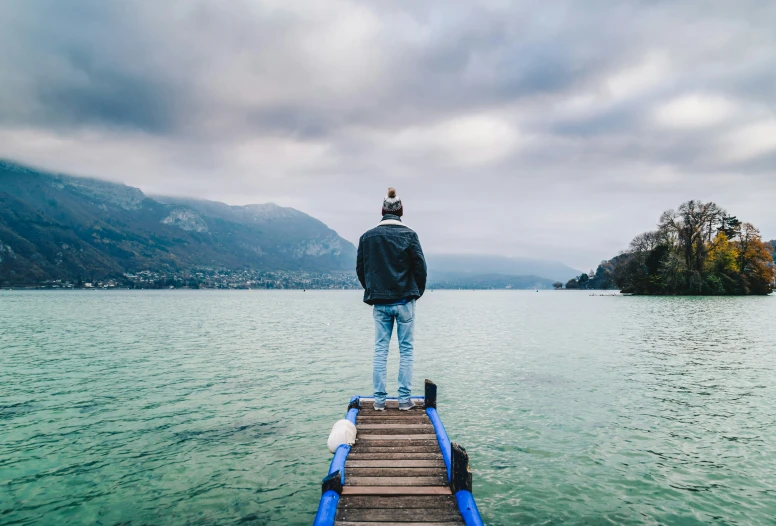 a person standing on top of a dock next to the water