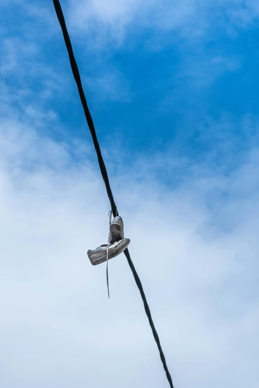 a pair of shoes hanging on to an old power line