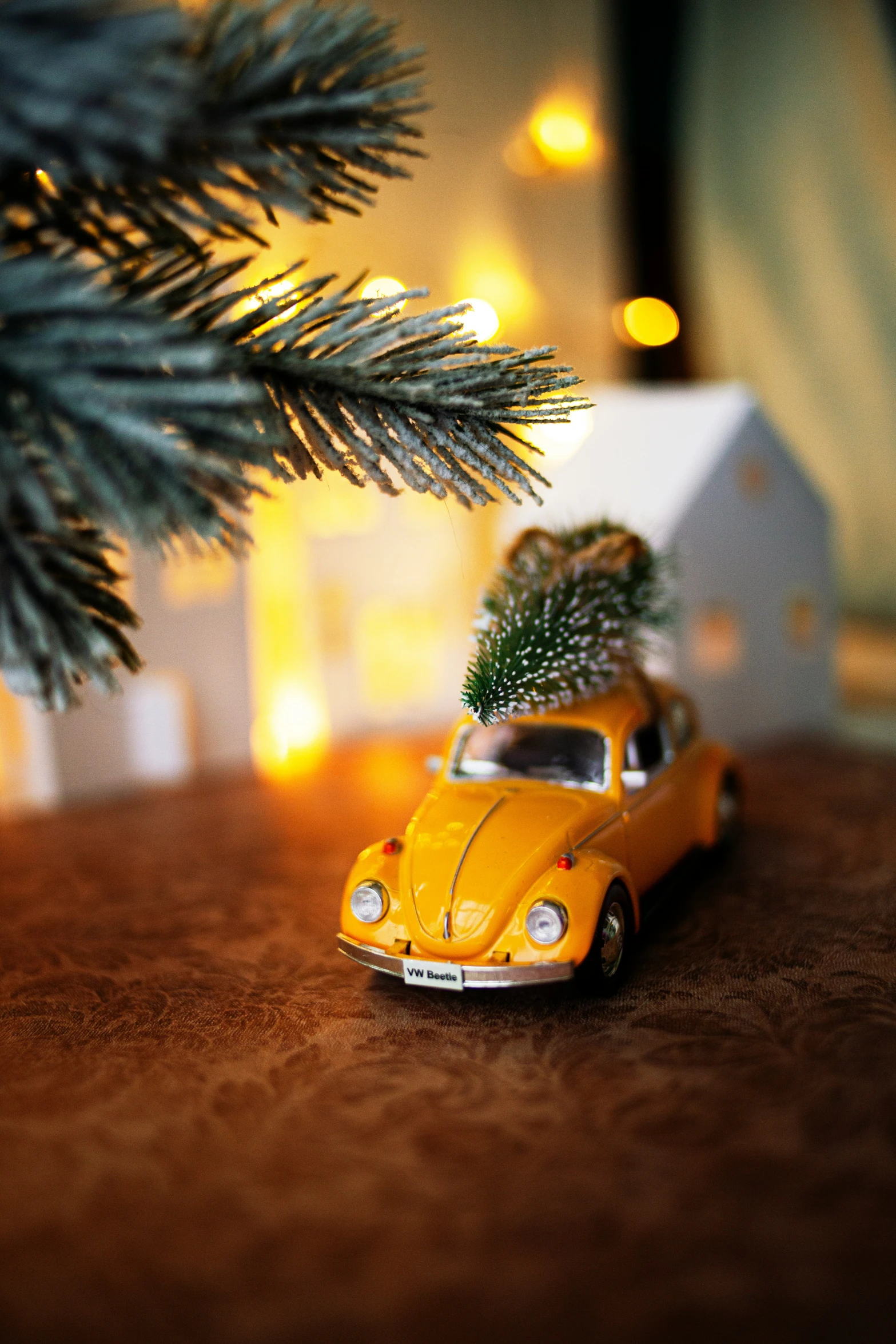 a toy car with a small tree on the top sits on a wooden table