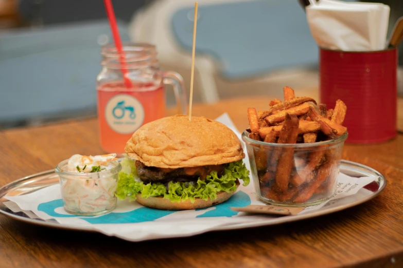 a plate of fries and a hamburger with dressing on it