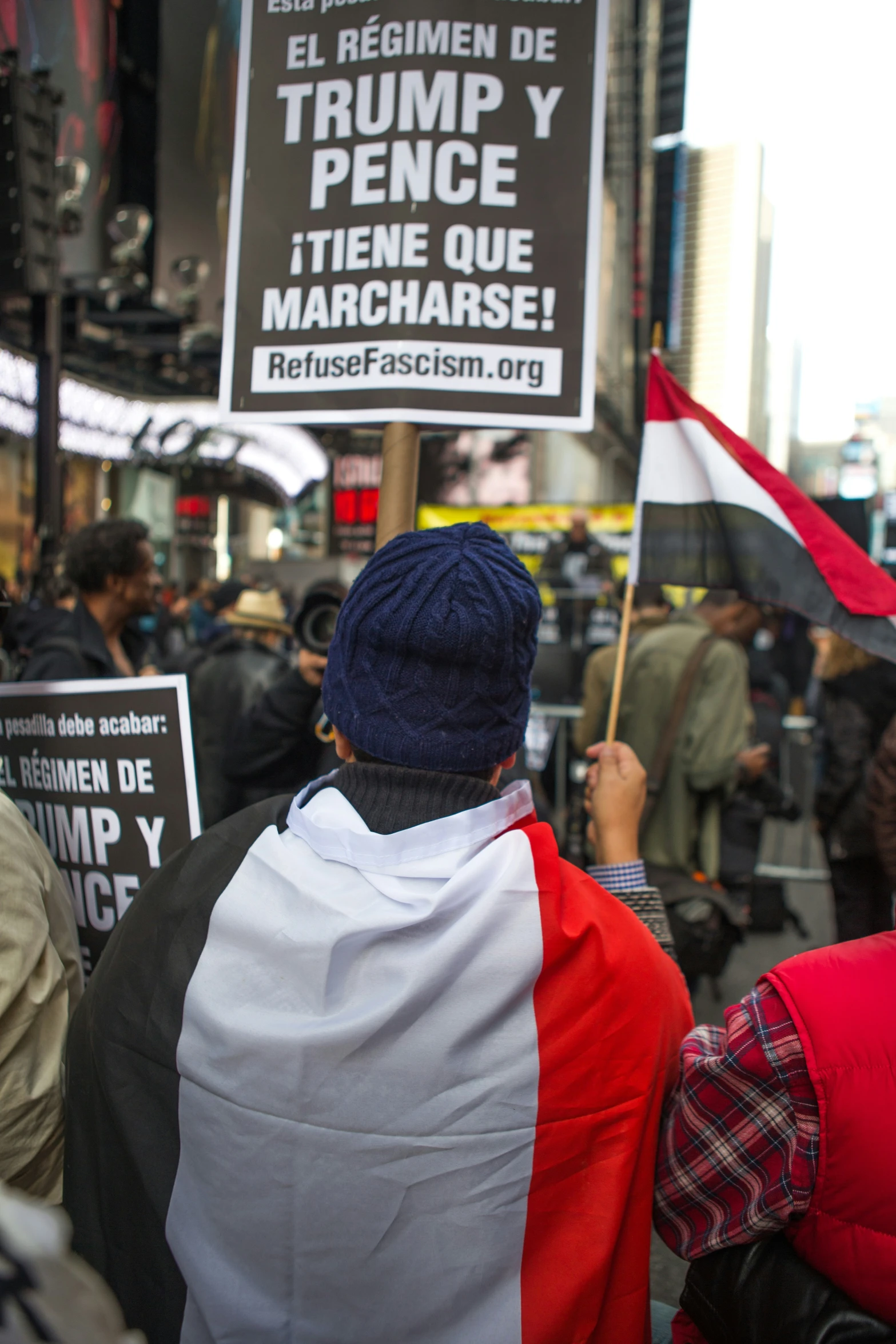 a group of people holding umbrellas and signs