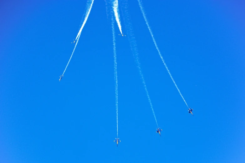 four airplanes fly in a straight line into the sky