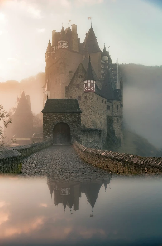 a castle surrounded by fog and low hanging clouds