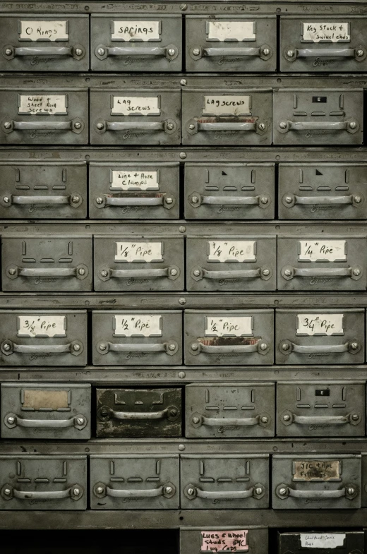 some drawers stacked high together and empty with labels on them