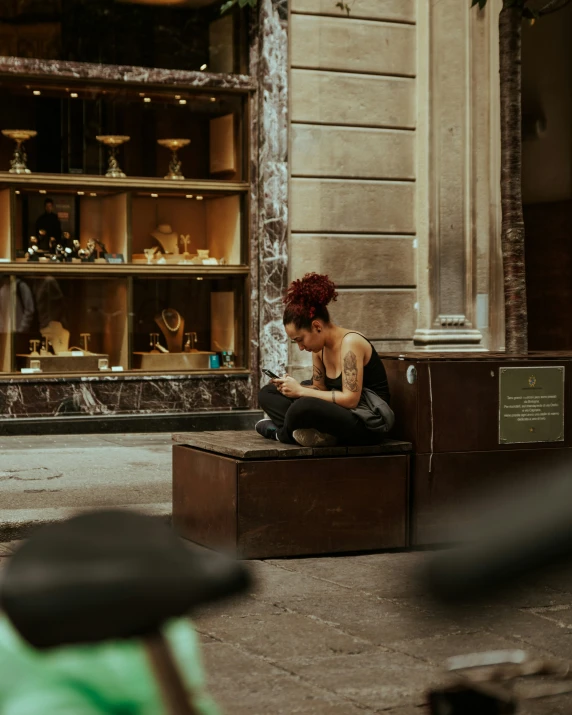 woman sitting on a box using her phone