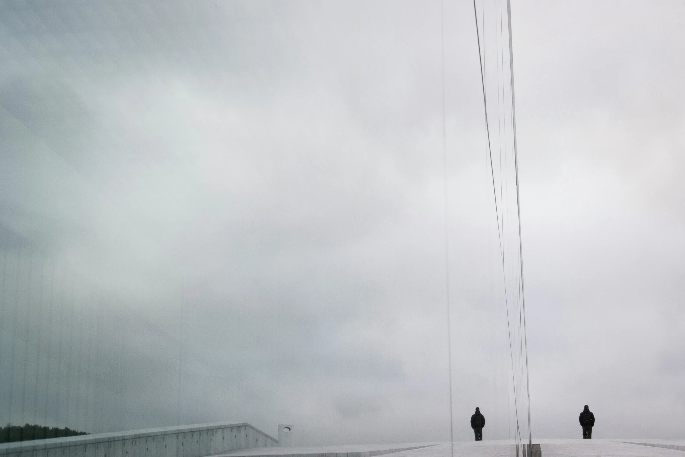 two people are standing on a bridge in the snow