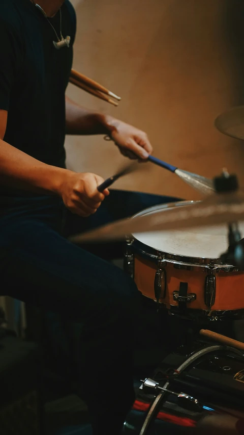 a person with their hand on a drumstick