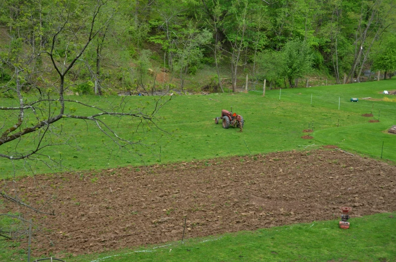 a farmer riding a tractor through a green field