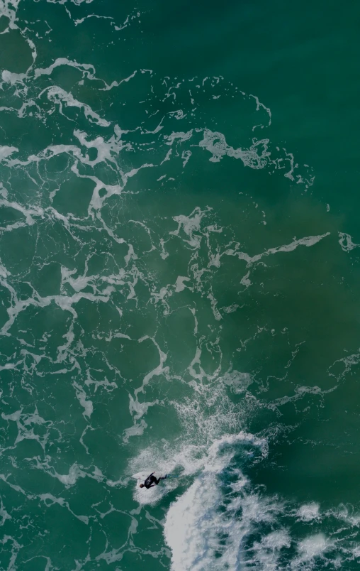 a surfer riding an orange surfboard in the ocean