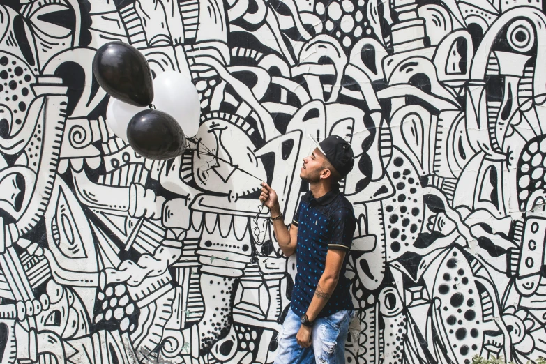 a man standing on the ground near a graffiti wall