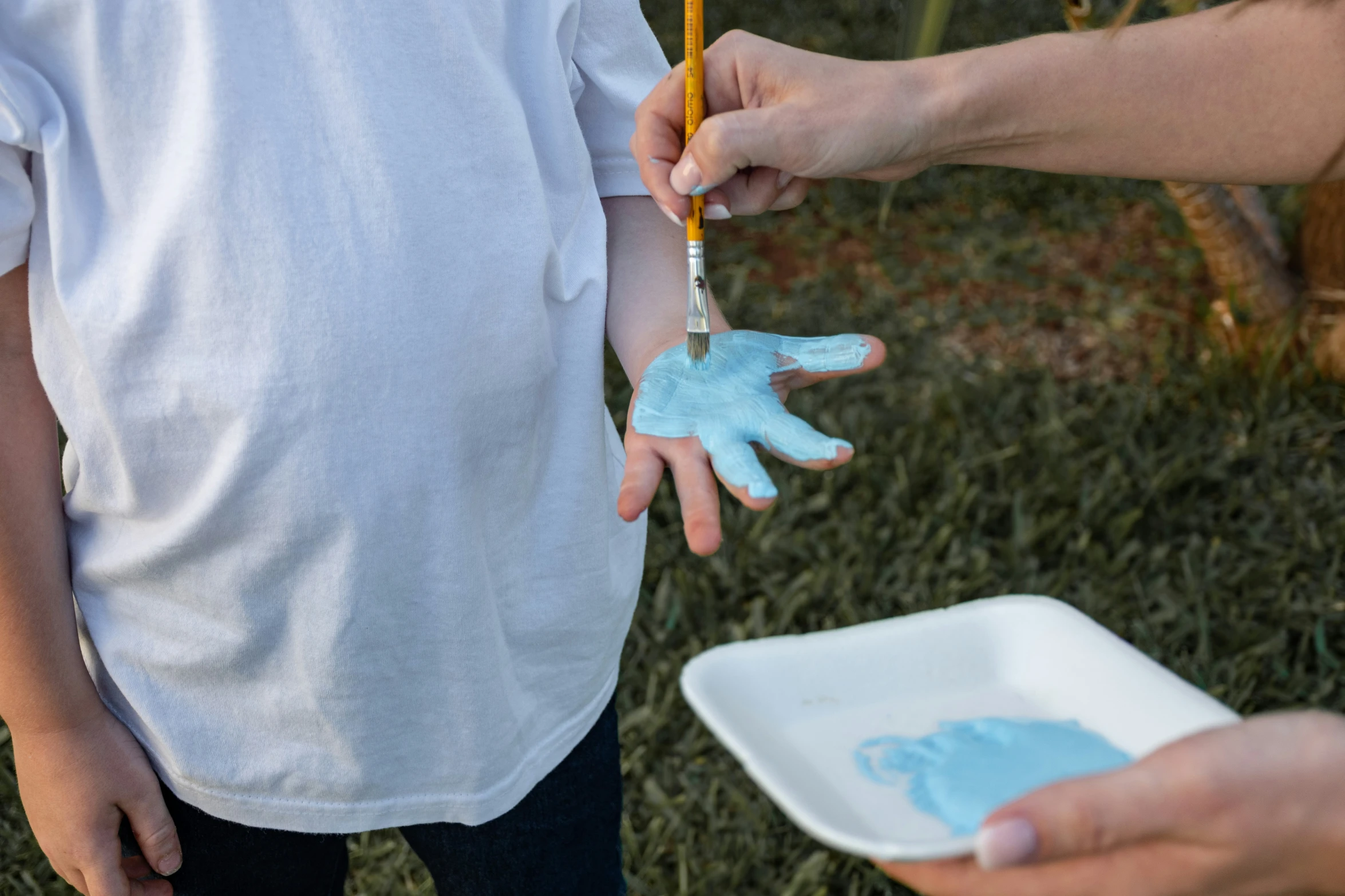 the child is getting his hands painted blue