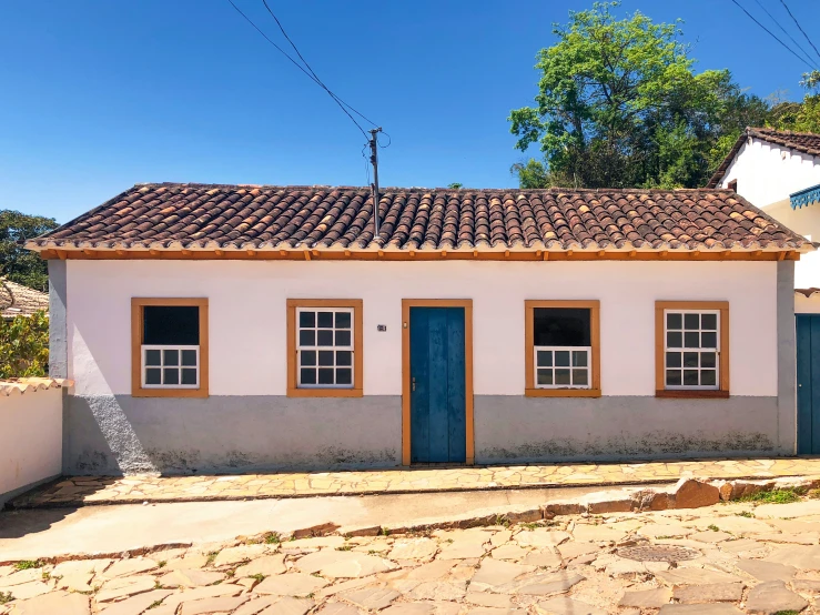 a small white house with blue doors on it's side