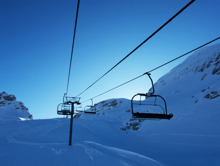 a skier coming down the hill under the lift