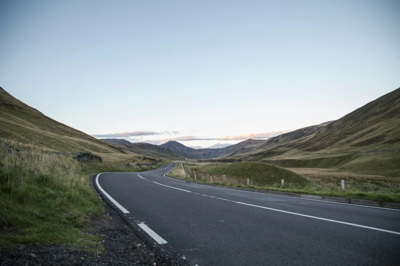 a long and empty road in the mountains