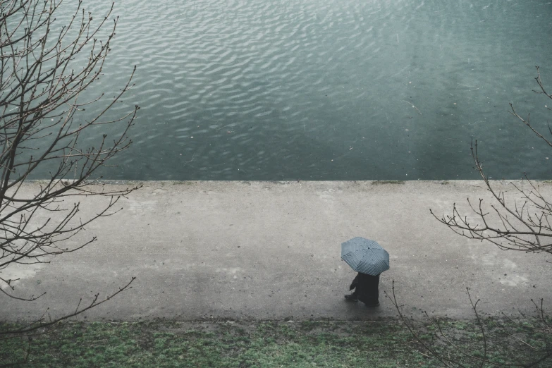 a person walking across a walkway with an umbrella