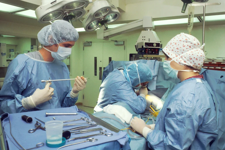 three surgeons doing  in a surgical room