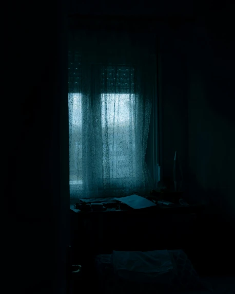a dark room with a bed and a window