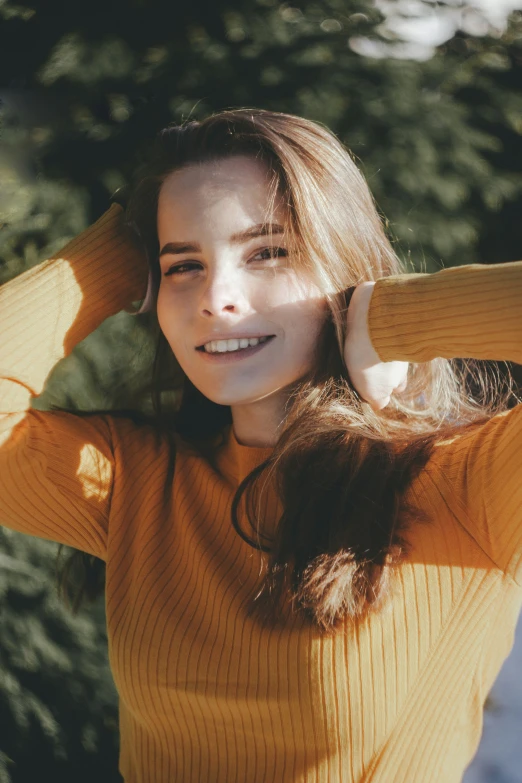 a beautiful young woman in yellow sweater posing for a po