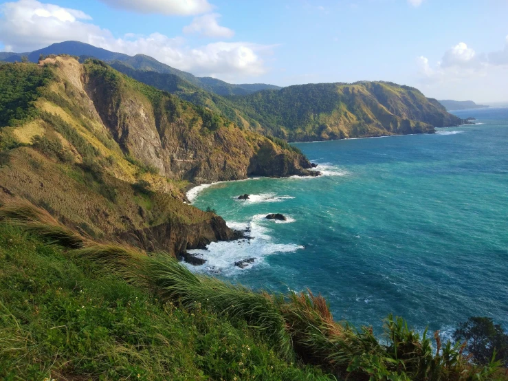 an ocean cliff with a beautiful view looking out to the mountains