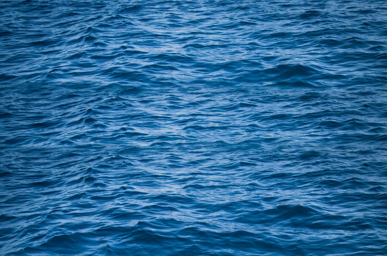 the background of a dark blue ocean with ripples