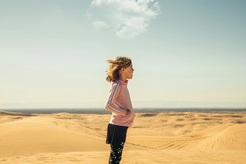 a person in a pink top and pants looking out at the distance