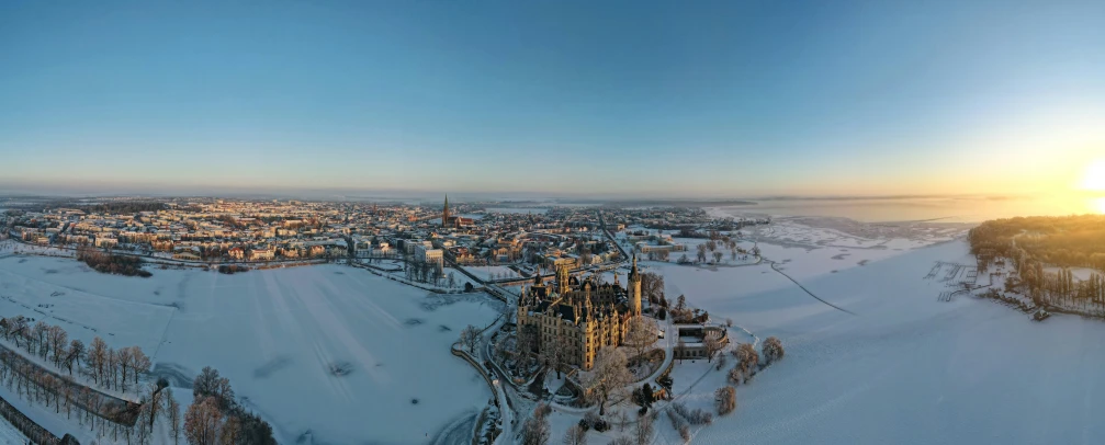 a city is covered in snow as the sun rises