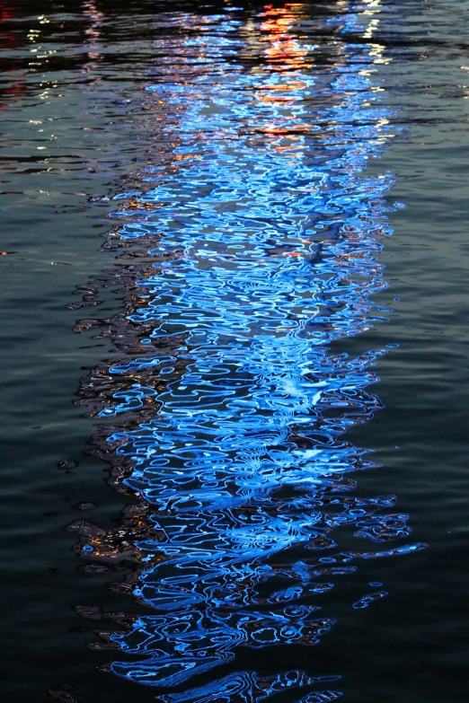 a blue sky reflecting on the water of a lake