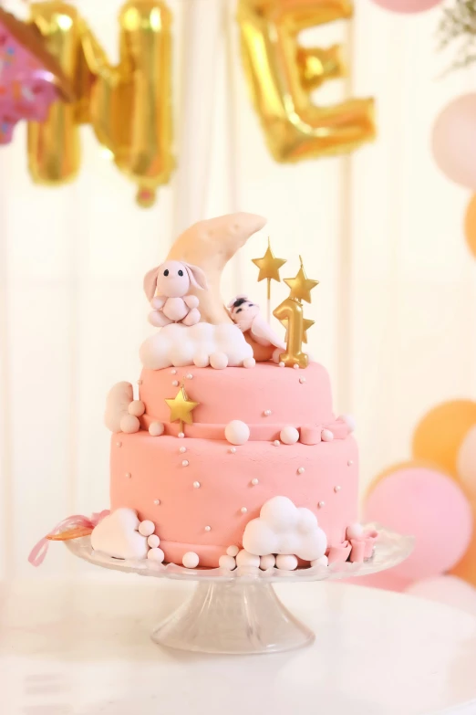 a small cake has a teddy bear and other stars on top