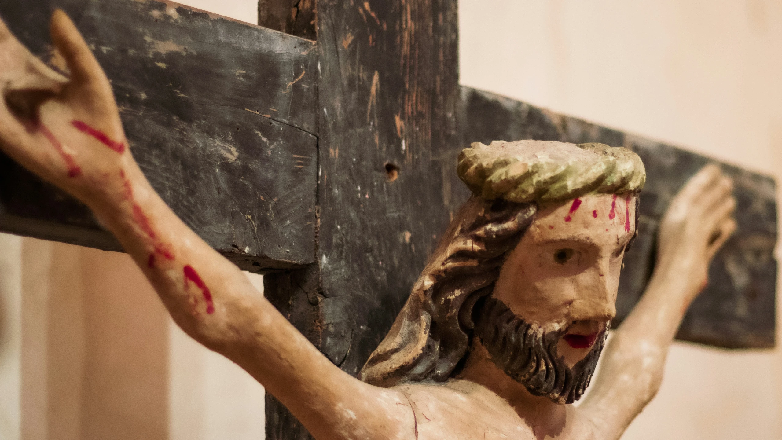 a sculpture of jesus nailed to the cross with  on his arm