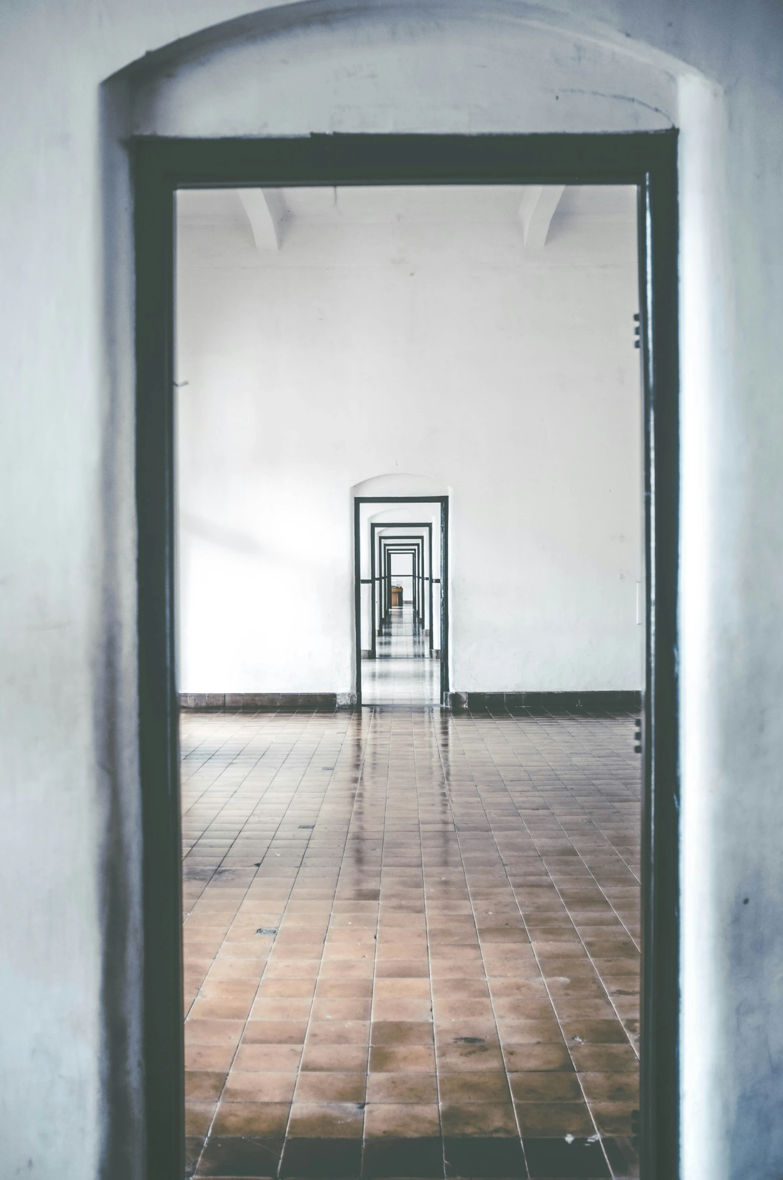 the door to an open, white room with tiled floor