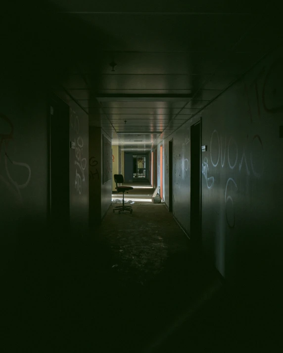 the dark hallway is dimly lit with graffiti