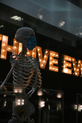 a skeleton statue standing in front of a sign