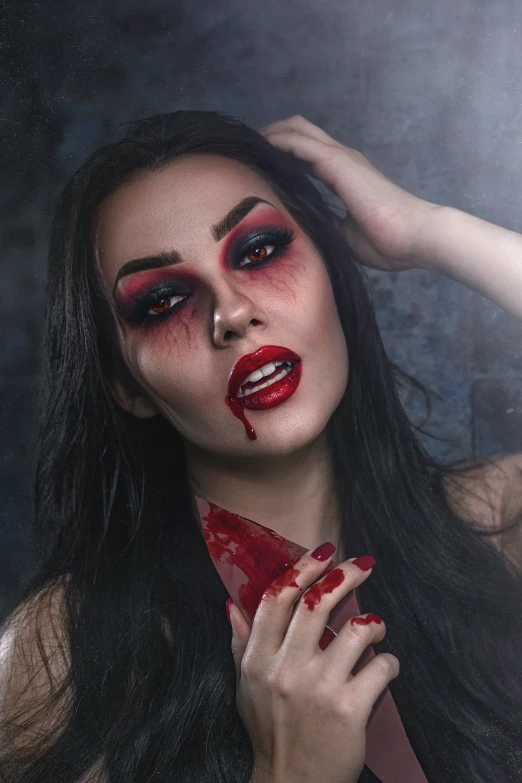 a young lady wearing dark makeup and red makeup