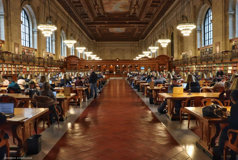 there are many people sitting at the tables reading