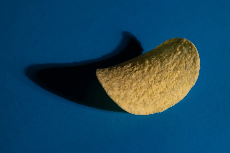 a potato wedge that is partially eaten on a blue background